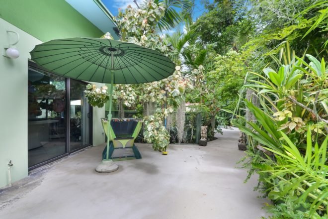 patio with chair under green umbrella