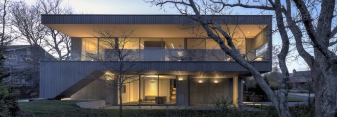 gray concrete home lit up at dusk