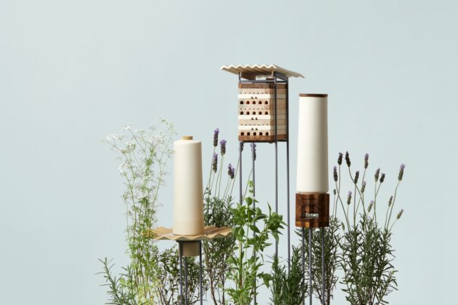 three small white and wood shelters for bees on blue background