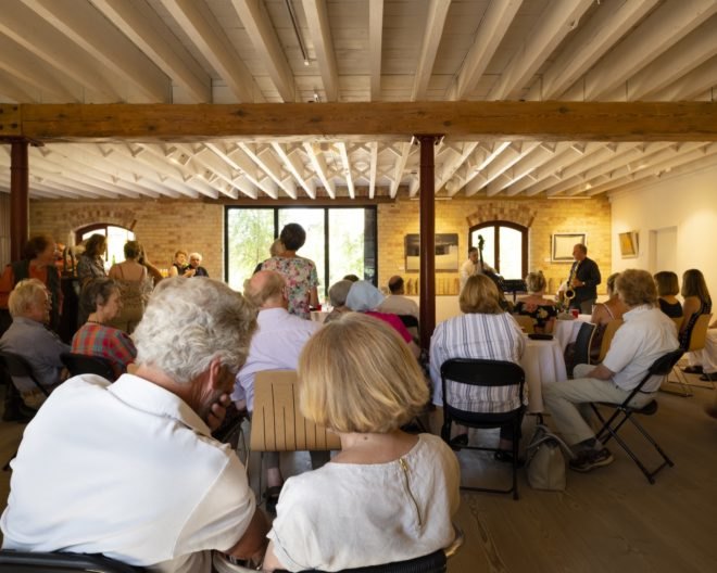 crowd of people inside a brick-lined room
