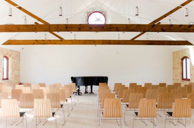 bright event space with wooden seats and wood ceiling beams