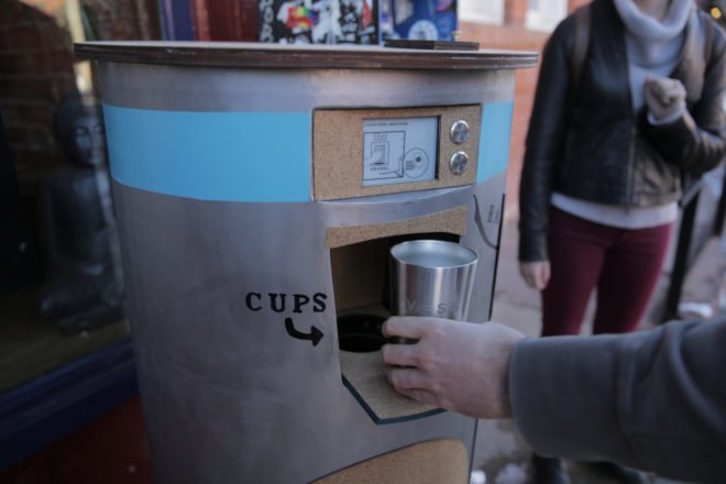 stainless steel mug being dropped off at kiosk