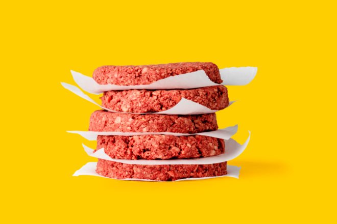 a stack of fake meat patties on yellow background