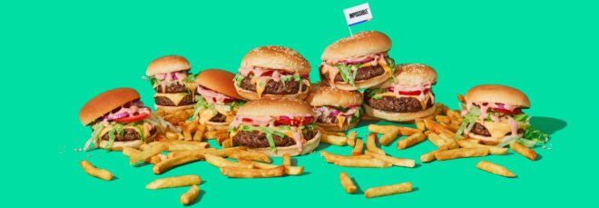 cheeseburgers and fries on a teal background