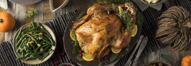 turkey, green beans, mashed potatoes, cranberry sauce, gravy, stuffing and pumpkin pie on a table