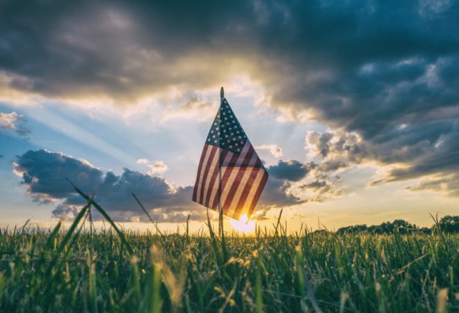 American flag in grass at sunset