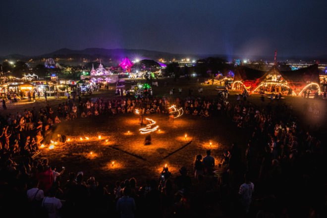 people dancing around fire at night