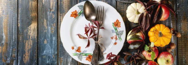 aerial view of plate and silverware near leaves, pumpkins and apples