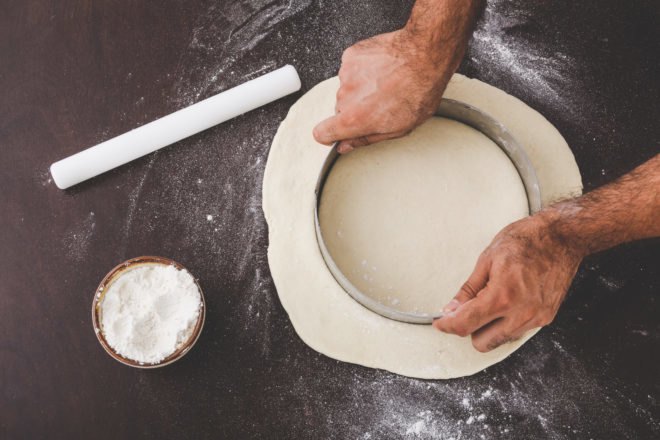 person cutting circle in dough