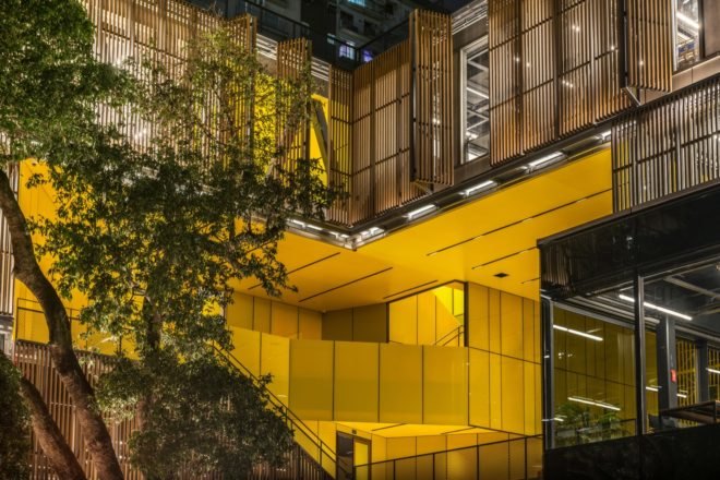 glass building with bright yellow patio and staircases