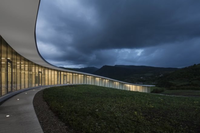 curved glass building at dusk