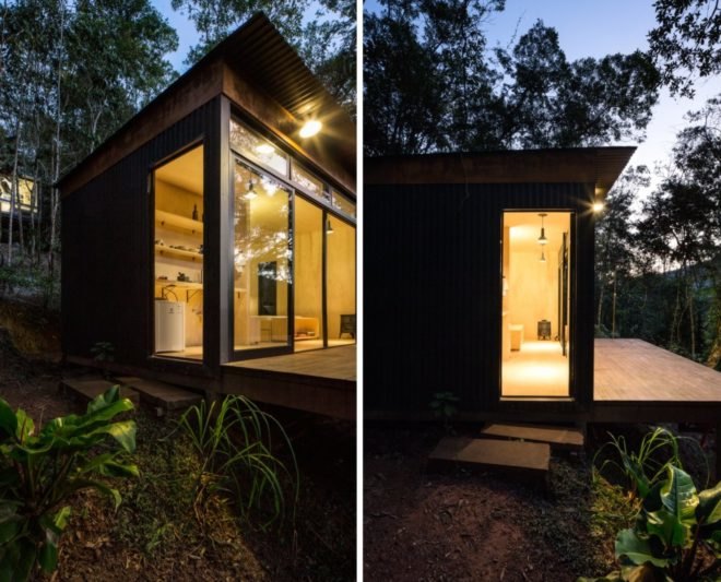 Tiny black cabin illuminated at night