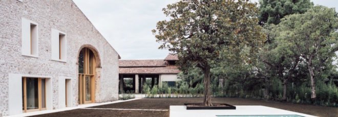 stone home with several surrounding trees