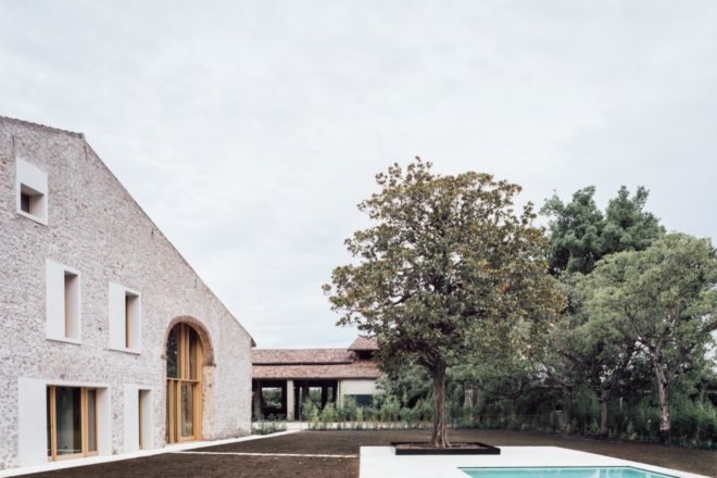 stone home with several surrounding trees