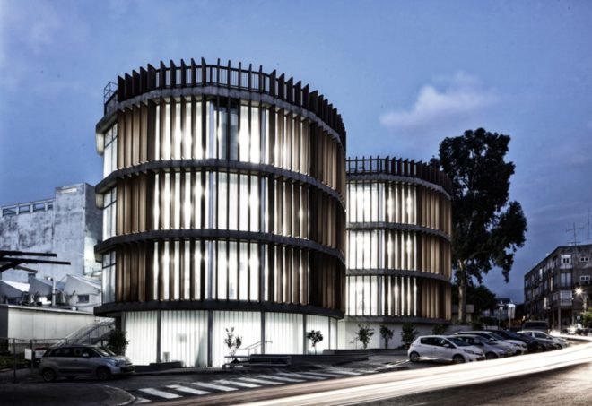 ECO-TUBES building is illuminated at night with bright lights from the interior