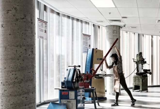 Woman is working with red machinery