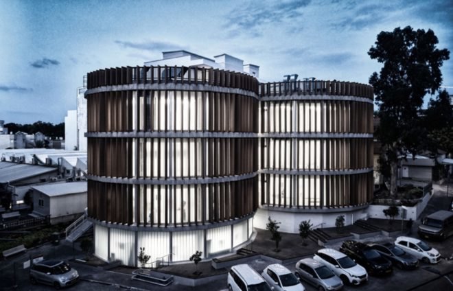 ECO-TUBES building is illuminated at night with bright lights from the interior