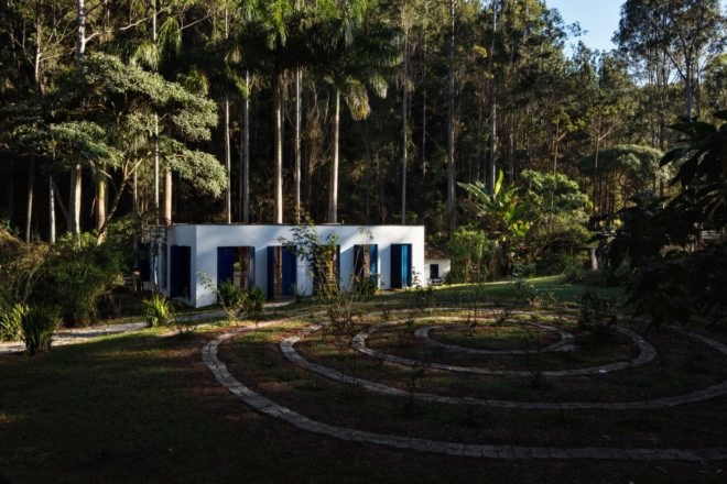 white building with blue shutters surrounded by trees