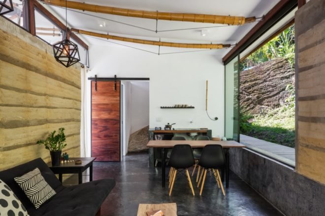 living area with small wood dining table and kitchen