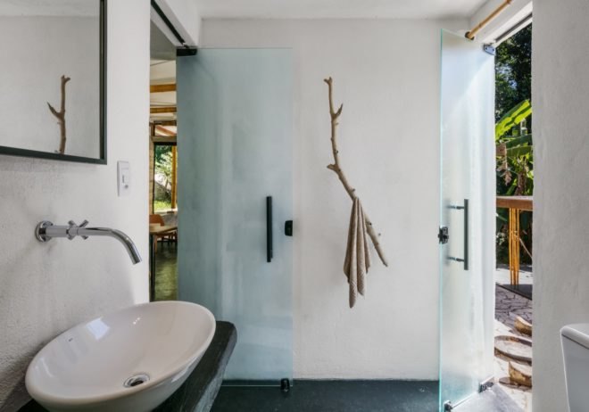 white bathroom with tree branch as a towel holder