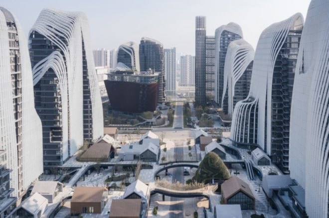 village-like mixed-use development between skyscrapers in city