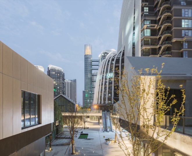 trees and plants line the interior structure of the project surrounded by buildings