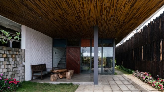 small patio-like area underneath structure with wood furniture and flowers