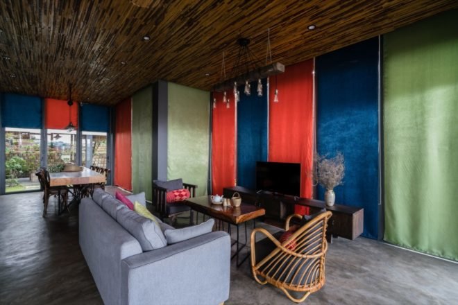 Interior of living room filled with light and colorful curtains covering the large windows