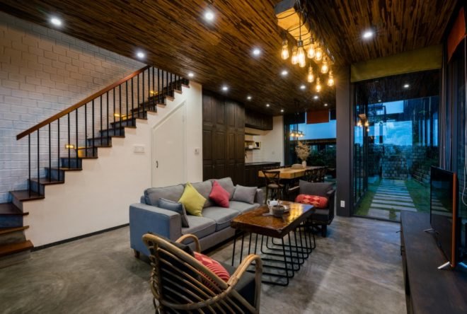 interior of hotel with couches and the dining area in the back adjacent large windows near wood cabinets