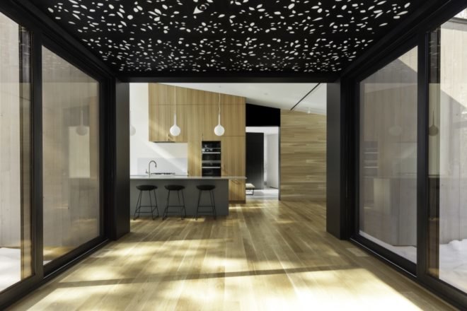 wood floors line the interior of the kitchen area along with a suspended aluminum ceiling