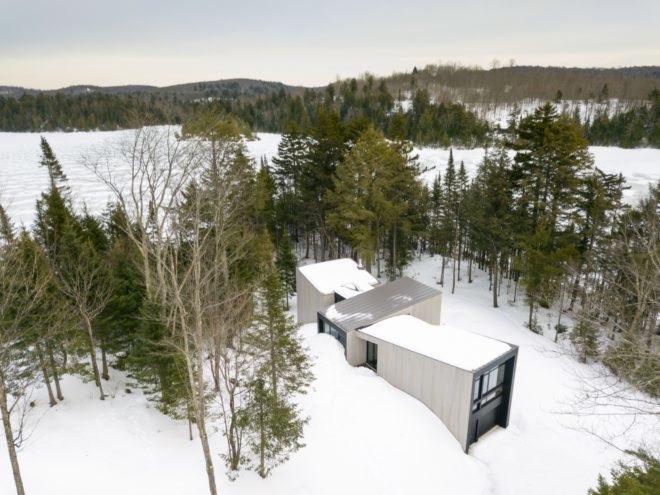 aerial view of the minimalist home surrounded by greenery and snow