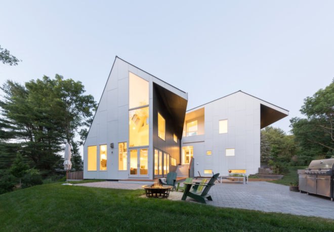 white and gray home with geometric roofs and windows