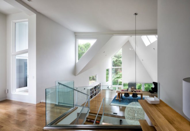 living space with angular ceilings and multiple windows