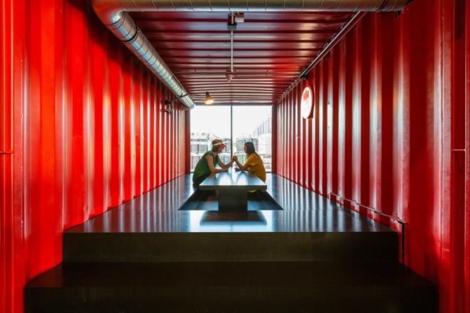 two people talking over a long black table