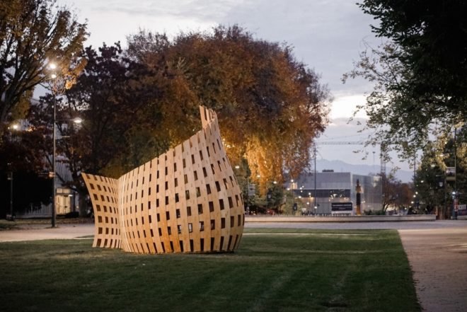 curved wood pavilion on grassy lot
