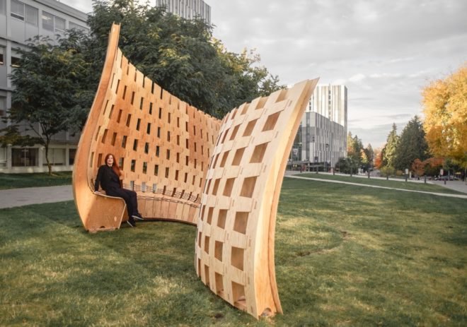 person sitting on curvy wood structure
