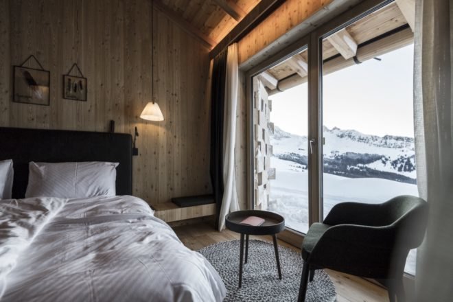 bedroom with large windows with snow covered mountains