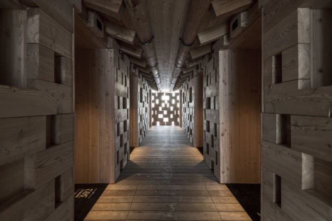 long wood lined corridor inside hotel with light shining in through back wall