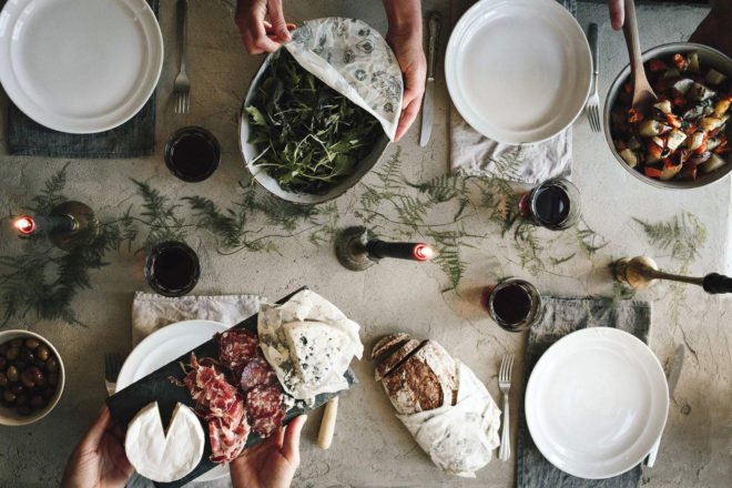 table set with dishes filled with food and covered by reusable food wrap