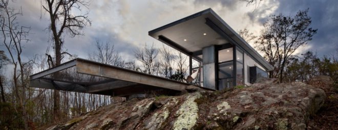 two flat roofs of a cabin jutting out over a rocky ledge