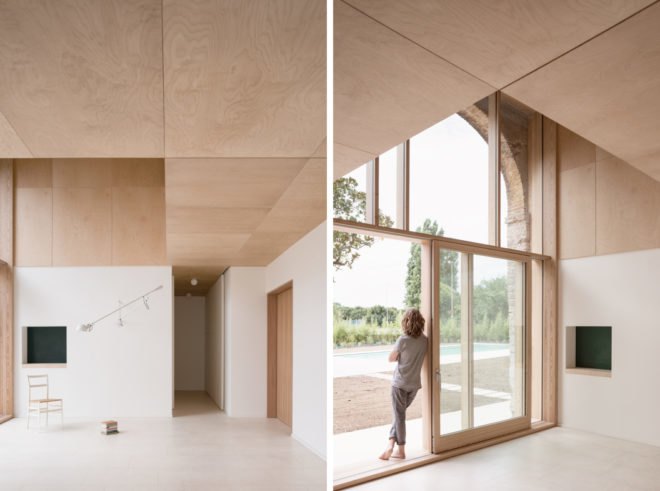 White room with light timber ceilings and large windows