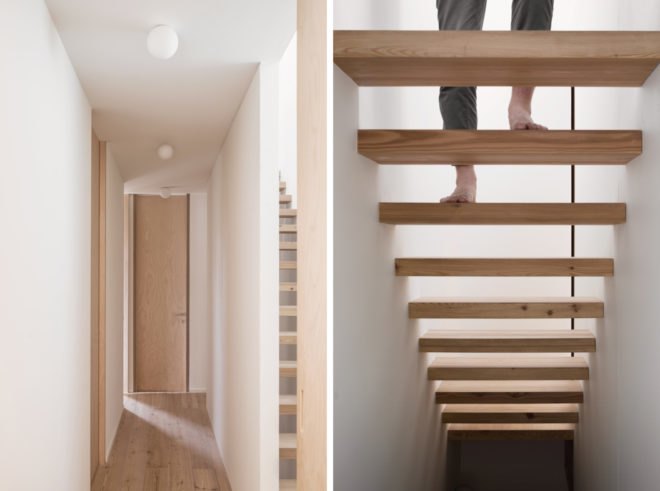 White hallway with light timber doors and light timber floating stairs