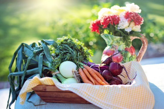 basket of vegetables on a table at sunset