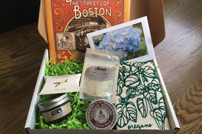 box opened to reveal a book, sea salt, a tea towel, caramels and chocolate