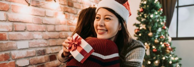 two best friends hugging and holding presents
