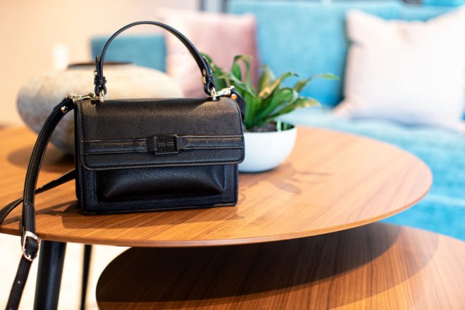 black vegan leather purse on wood coffee table