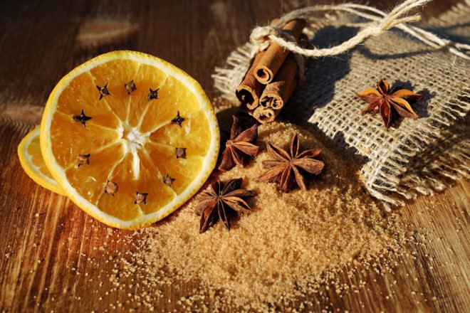 oranges, anise, sugar and cinnamon on wood table