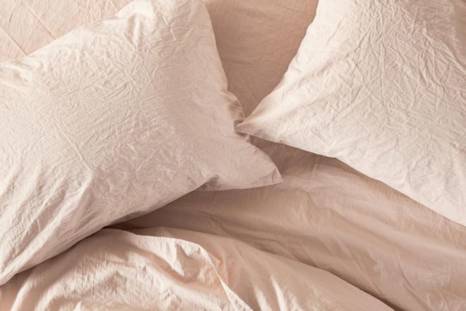 blush pink wrinkled bed sheets and pillow covers