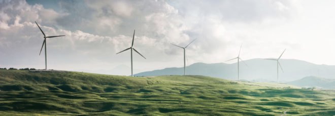 windmills on rolling green hills
