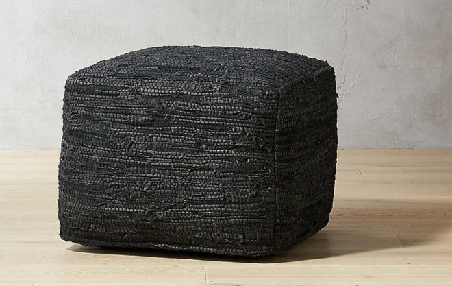 black pouf seat on wooden floor